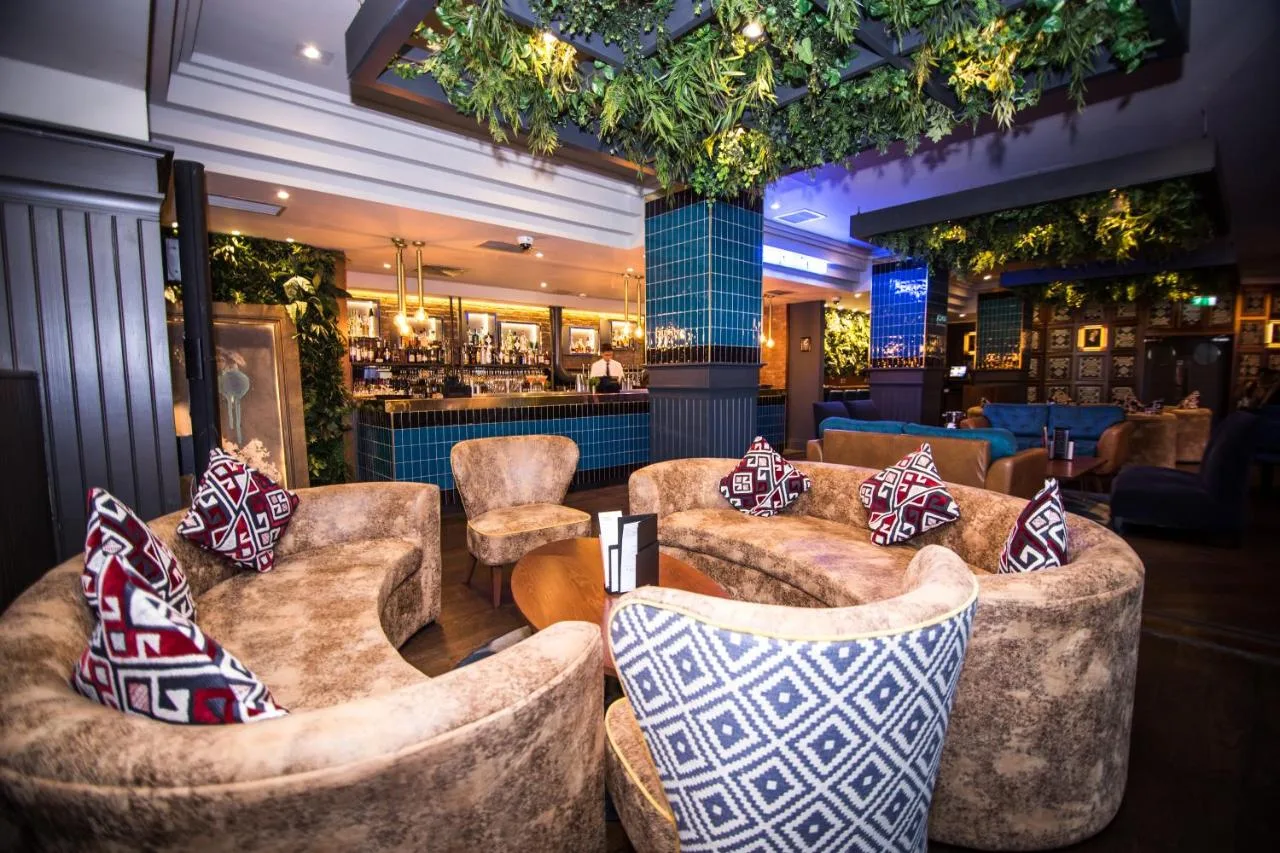 A lobby with couches and a bar in the background at Malmaison Newcastle in Newcastle upon Tyne