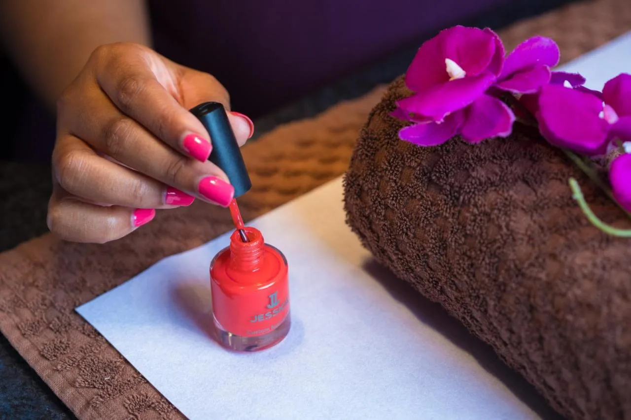 A woman with pink nail polish holding a bottle of nail polish at Malmaison Newcastle in Newcastle upon Tyne