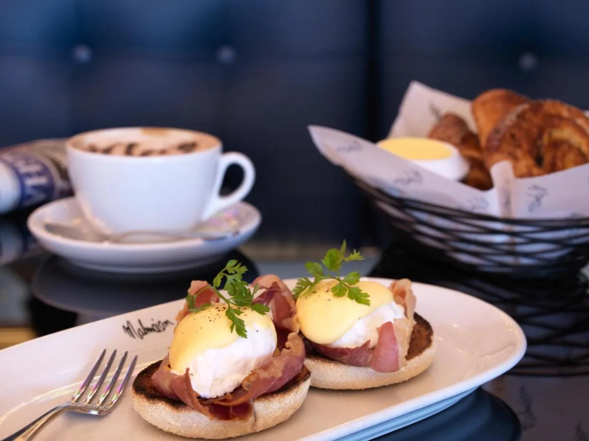 A plate with two breakfast sandwiches and a cup of coffee at Malmaison Newcastle in Newcastle upon Tyne